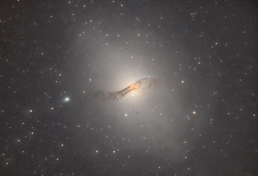 Look though! A large bright oddly shaped galaxy with a dark dust band across it